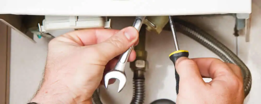 Boiler repair technician tightening pipe fittings and connections in Indianapolis, IN