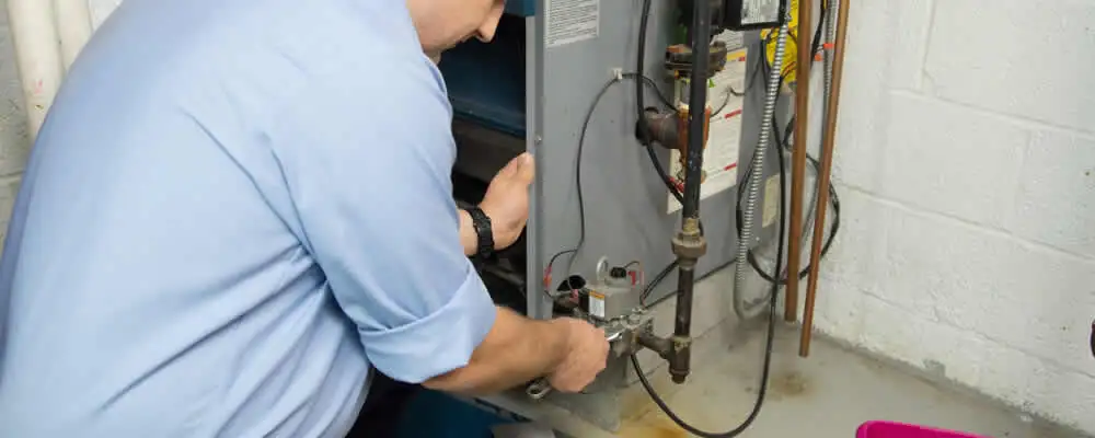 Furnace repair technician inspecting and servicing a home heating system in Indianapolis, IN