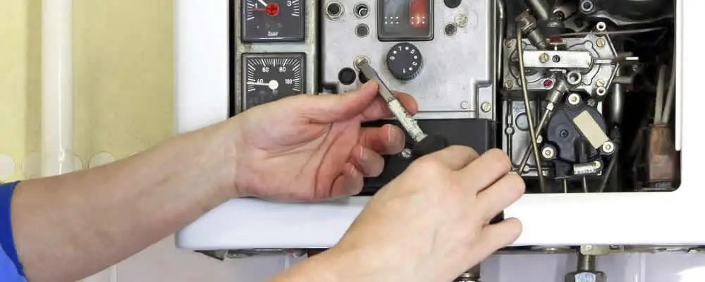 Heating repair technician adjusting boiler controls and components in Indianapolis, IN
