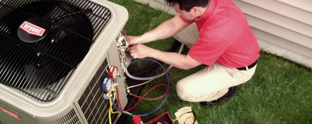 HVAC technician servicing an outdoor air conditioner unit in Indianapolis, IN
