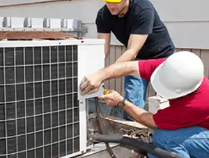 HVAC technicians repairing an outdoor AC unit on a rooftop in Indianapolis, IN