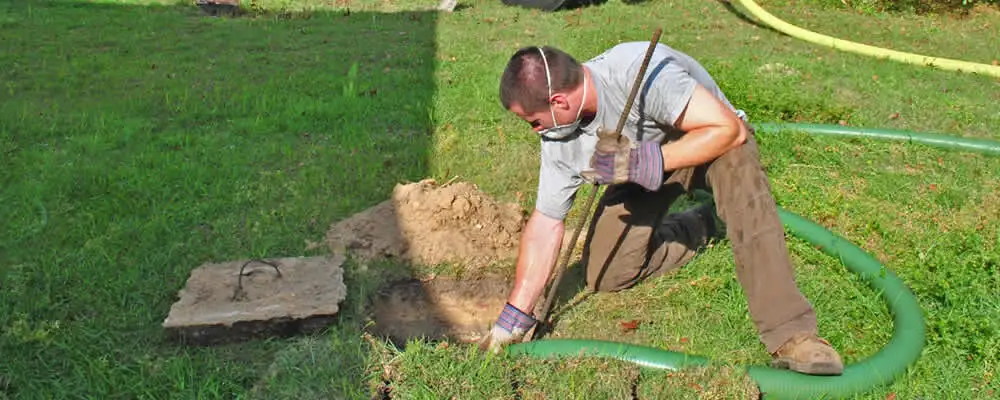 Septic pumping technician servicing a residential septic tank in Indianapolis, IN