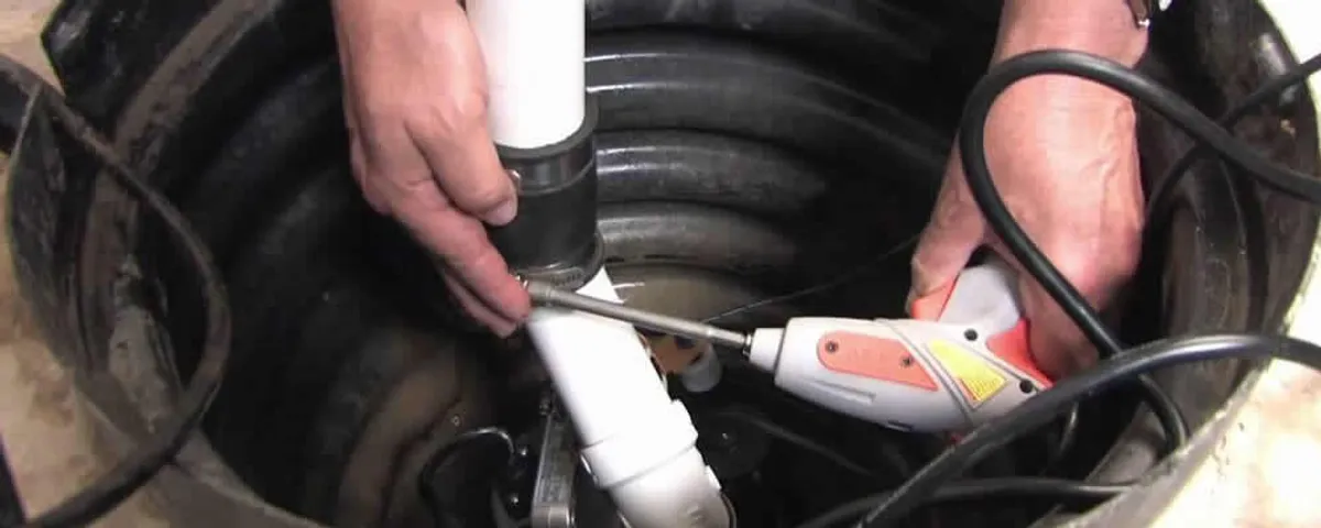 Sump pump installation technician connecting PVC discharge piping in Indianapolis, IN