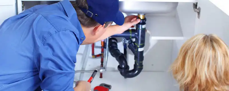 Plumber repairing under-sink drain pipes and fittings in Indianapolis, IN